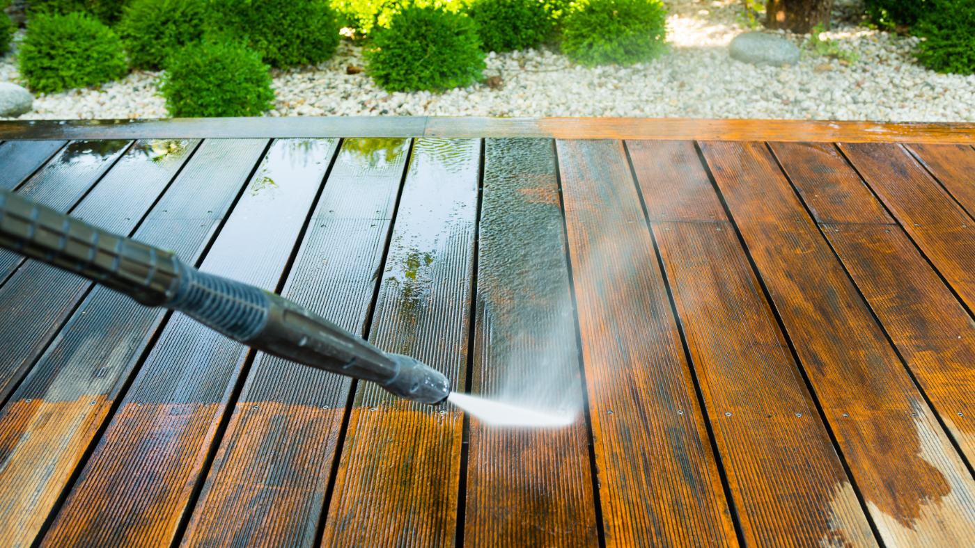 Pressure washing wooden deck boards with white water spray and jet nozzle