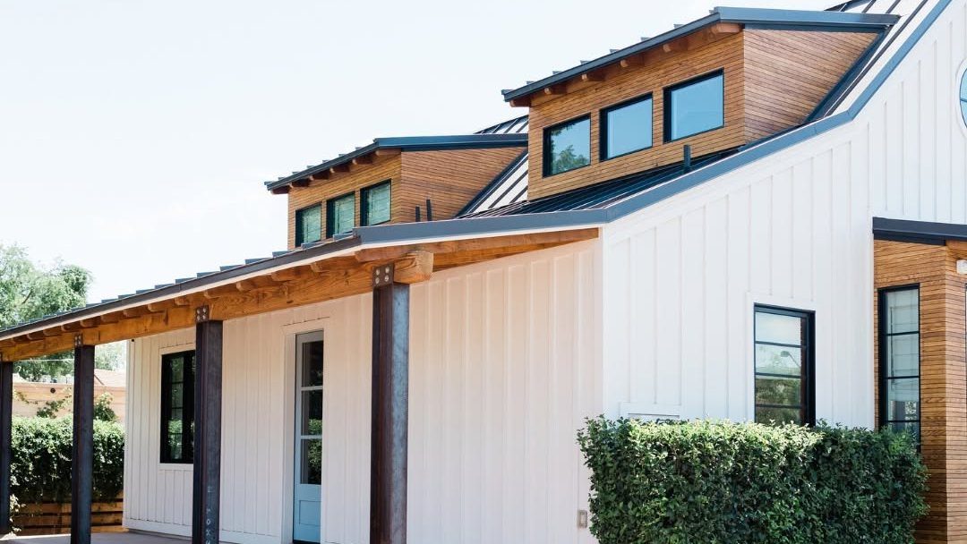 Modern farmhouse home with white corrugated siding and wood accents