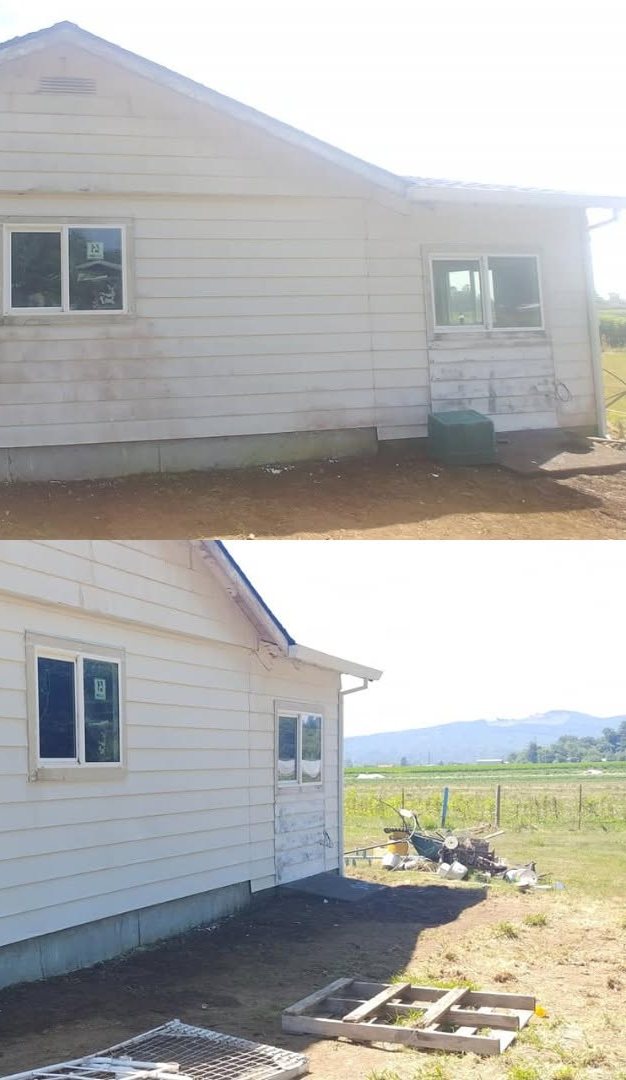 White mobile home with foundation work and landscaping in rural setting